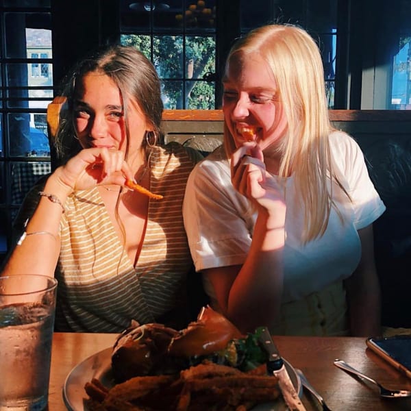 Two young women enjoying a meal of fries and chicken at The Kettle diner.