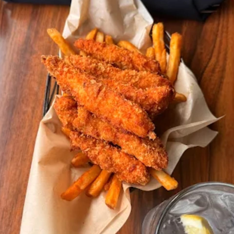 A basket of crispy chicken tenders and golden french fries from The Kettle diner.